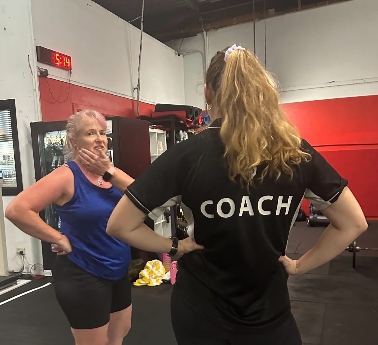 A Knight Fitness coach guiding a member through a lift